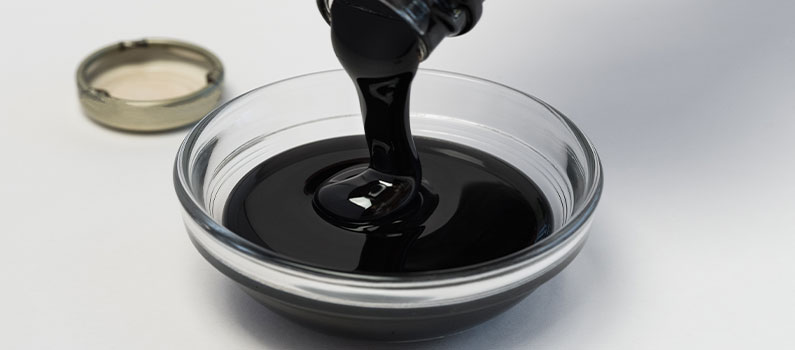pouring unsulfured molasses for plants in glass bowl